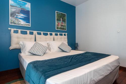 a bedroom with a large bed with blue walls at Villa Lou Santen Guadeloupe in Saint-François