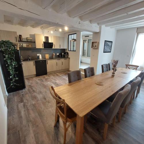 mesa de comedor con sillas y cocina en Gite le 19 - Maison 130m2 - Les Rosiers sur Loire - Chambres climatisées, en Les Rosiers