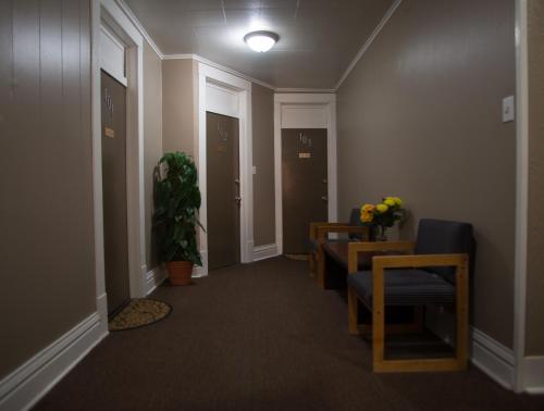 um corredor com cadeiras e uma mesa num quarto em Rosemount Motel em Bedford