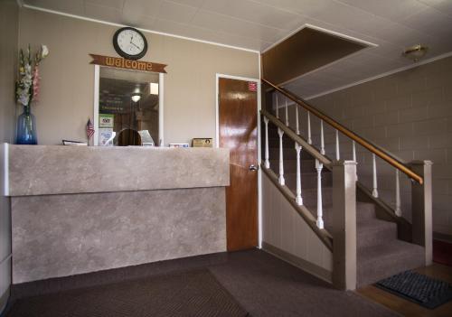 a lobby with a staircase and a clock on the wall at Rosemount Motel in Bedford