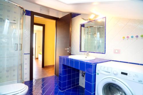 a bathroom with a sink and a washing machine at Bright apartment in Acireale, 60 sqm with shared pool in Acireale