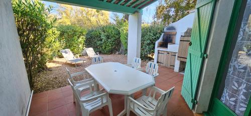 une table blanche et des chaises sur une terrasse dans l'établissement ST CYPRIEN C18 -4/6 pers- CLIM- à 250m de la plage de sable Saint Cyprien, à Lecci