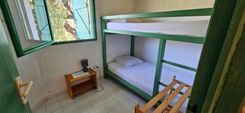 a small room with two bunk beds and a table at ST CYPRIEN C18 -4/6 pers- CLIM- à 250m de la plage de sable Saint Cyprien in Lecci