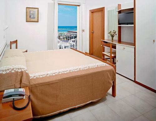 Hotel Saint Tropez SPA & Restaurant في ليدو دي سافيو: غرفة نوم مع سرير وإطلالة على المحيط