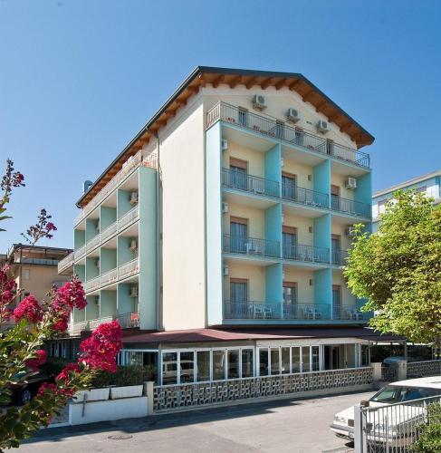 a large white building with balconies on a street at Hotel Saint Tropez SPA & Restaurant in Lido di Savio