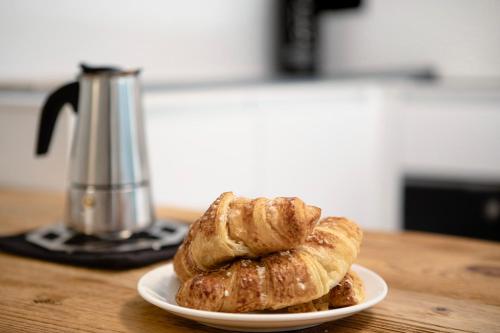 a plate of croissants on a table with a coffee pot at Valgrisa Mountain Lodges 3 in Valgrisenche