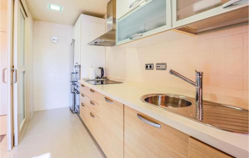 een keuken met houten kasten en een wastafel bij Nice Apartment In Los Alczares With Wifi in Los Alcázares