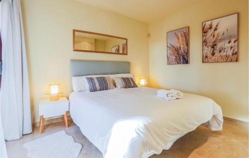 een slaapkamer met een groot wit bed en een spiegel bij Nice Apartment In Los Alczares With Wifi in Los Alcázares