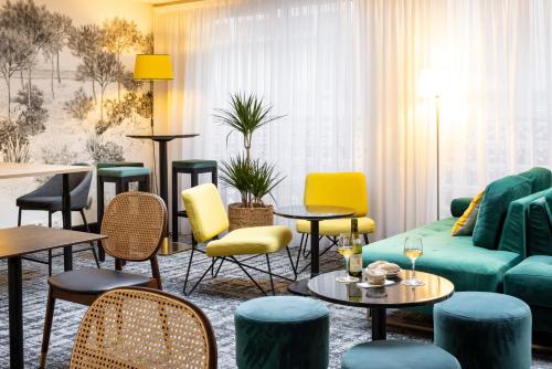 a living room with a couch and chairs and tables at Hotel Residence Europe & Spa in Clichy