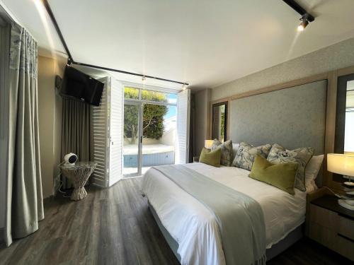 a bedroom with a large white bed and a window at Aquarella 2 in Plettenberg Bay