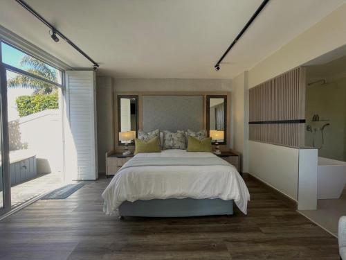 a bedroom with a large bed and a large window at Aquarella 2 in Plettenberg Bay