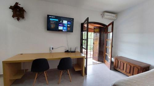 a room with a wooden desk and two chairs at Lindo estúdio perto do Hospital BOS Sorocaba (3) in Sorocaba