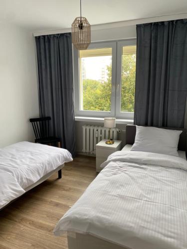 1 dormitorio con 2 camas y ventana en Tabago Studio 12, en Kędzierzyn-Koźle