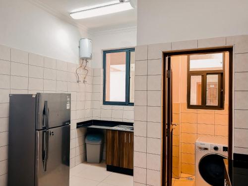 ダル・エス・サラームにあるElles Residenceのキッチン(ステンレス製の冷蔵庫付)、窓が備わります。