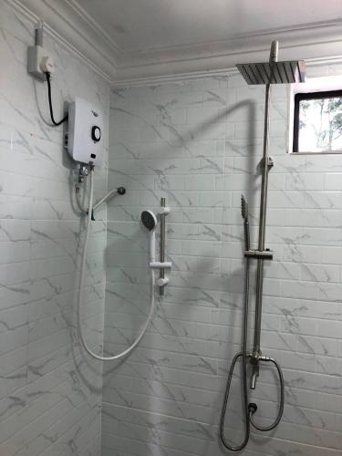 a shower with a glass door in a bathroom at Abe.Cottage 3 in Kampong Chawat