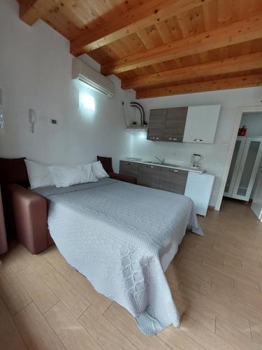 a bedroom with a large bed and a kitchen at Pizzocolo resort fasano in Gardone Riviera