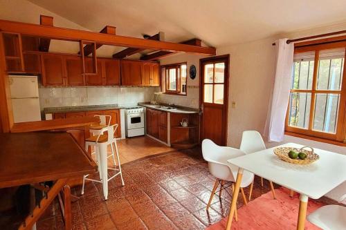 - une cuisine avec une table et une table et des chaises blanches dans l'établissement Hermosa casa de espacios amplios, à Punta del Este
