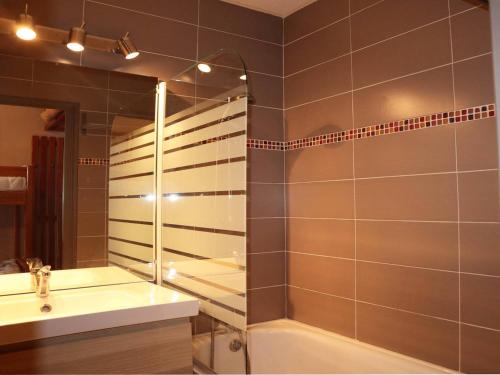 łazienka z wanną, umywalką i lustrem w obiekcie Studio 4 pers en cœur de station, balcon vue montagne - FR-1-322-500 w mieście Les Orres