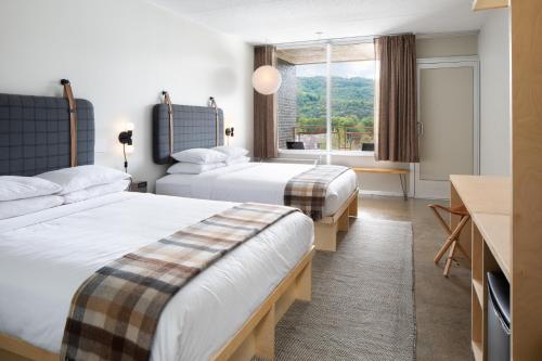 ブーンにあるRhode's Motor Lodgeのベッド2台と窓が備わるホテルルームです。