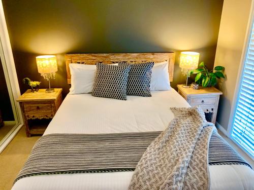 a bedroom with a large bed with two night stands at Bella Farm Country House Hunter Valley in Nulkaba