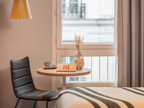 a room with a table and a chair and a window at Ibis Paris Gare Montparnasse Catalogne in Paris