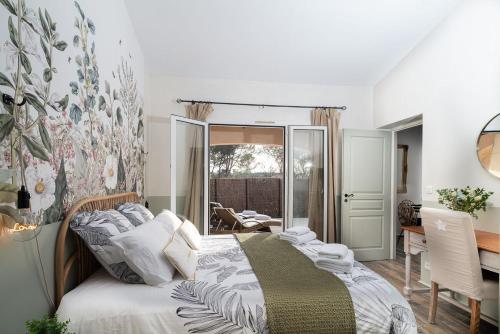 una camera con letto, tavolo e scrivania di Villa "L'émeraude - Maison d'Hôtes - Jardin et parking privés - Valbonne a Valbonne