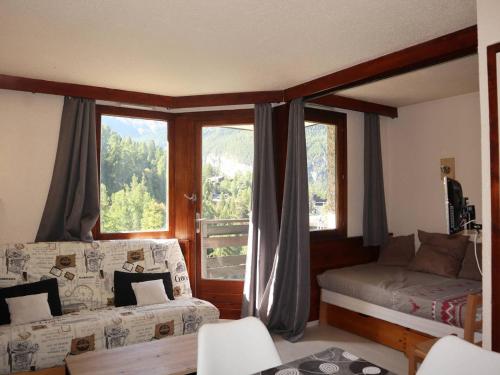 un salon avec un lit et une fenêtre dans l'établissement Grand studio skis aux pieds avec balcon, pour 4/5 pers, proche toutes commodités ! - FR-1-322-459, aux Orres