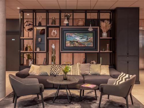 a living room with a couch and a table at Ibis Paris Gare Montparnasse Catalogne in Paris