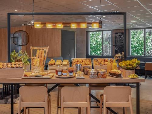 a large table with food on it with chairs at Ibis Paris Gare Montparnasse Catalogne in Paris