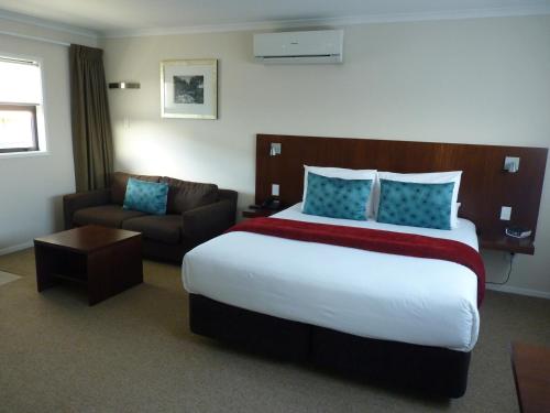 Habitación de hotel con cama grande y sofá en Astra Motor Lodge, en Hamilton
