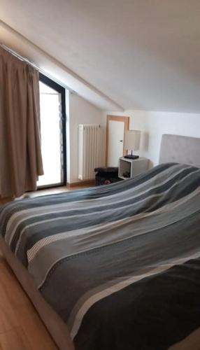 ein großes Bett in einem Zimmer mit Fenster in der Unterkunft Casa Fissore in Sommariva Perno