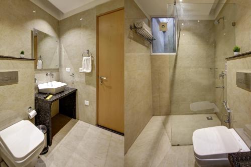 a bathroom with a shower and a toilet and a sink at Saltstayz Corporate Suite- Golf Course Road and Near galleria market in Gurgaon