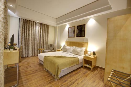 a hotel room with a bed and a television at Saltstayz Select - Galleria Market & Golf Course Road in Gurgaon