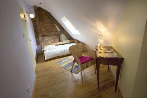 - une chambre avec un lit et un bureau avec une chaise dans l'établissement Chambres d'hôtes du Coq à l'Ane, à Beaubec-la-Rosière