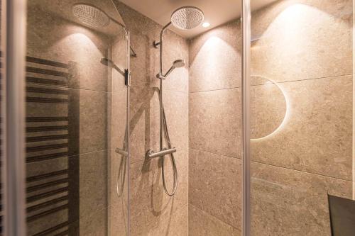a shower with a glass door in a bathroom at YUMA Apartments Leipzig Berliner Straße in Leipzig
