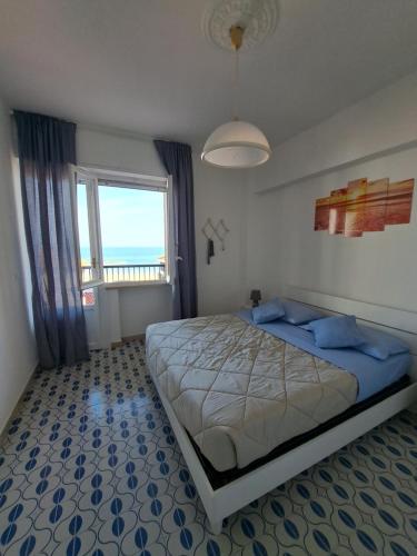 ein Schlafzimmer mit einem großen Bett und einem großen Fenster in der Unterkunft Bellavista fronte mare in San Benedetto del Tronto