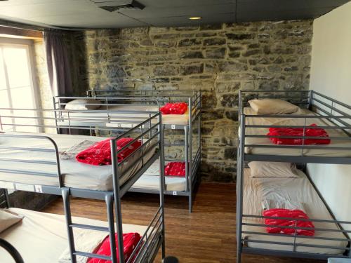 een groep stapelbedden in een kamer met een stenen muur bij Alt Hostel in Montreal