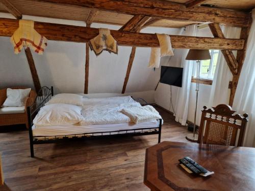 ein Schlafzimmer mit einem Bett in einem Zimmer mit einem Tisch in der Unterkunft Anno 1886 - Knepp-Hänel-Haus in Grünhainichen