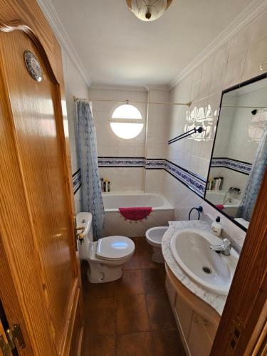 ein Badezimmer mit einem WC, einem Waschbecken und einer Badewanne in der Unterkunft CASA CARMELA in Quéntar