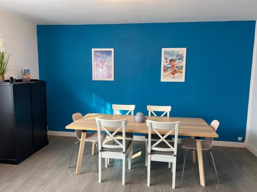 une salle à manger avec un mur bleu, une table et des chaises dans l'établissement Sandra, à Berck-sur-Mer
