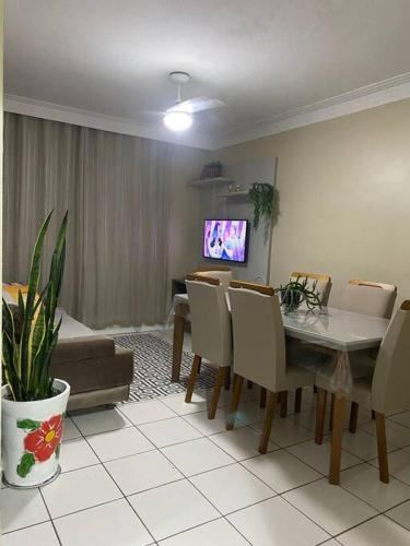 a living room with a table and chairs and a tv at Lindo apartamento in Aracaju