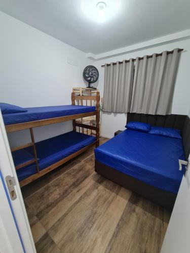 een slaapkamer met 2 stapelbedden en een raam bij Apartamento na Praia Martim de Sá com linda vista in Caraguatatuba