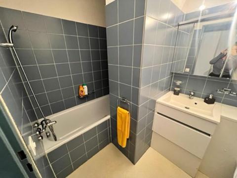bagno con vasca, lavandino e specchio di Beautiful 2.5 Room Apartment in Lucerne (Luzern)36 a Lucerna