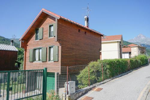 a brown house with a fence in front of it at Woodhouse paesana in Paesana
