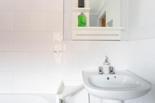 a white bathroom with a sink and a cabinet at Belfast City - 3 Bedroom Cosy Home - Walking Distance to City in Belfast