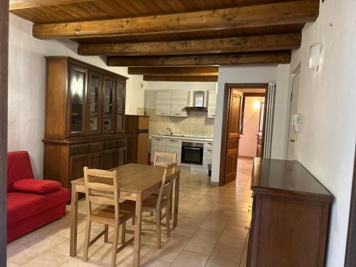 eine Küche mit einem Holztisch und einer roten Couch in der Unterkunft Casa Vacanze Oberje dla Viere in Oulx