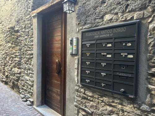 ein Steingebäude mit einer Holztür und einer Kommode in der Unterkunft Casa Vacanze Oberje dla Viere in Oulx