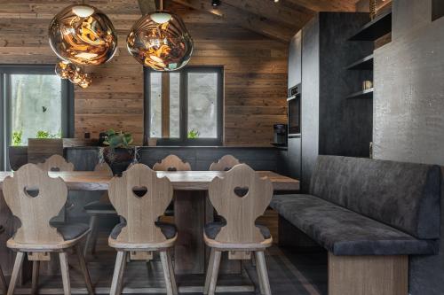 a dining room with a table and chairs and a couch at Kellnergut Luxus-Chalet "FRIEDA" in Mühlbach am Hochkönig
