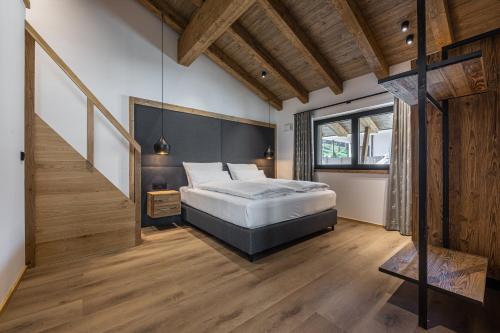 a bedroom with a large bed and a staircase at Kellnergut Luxus-Chalet "FRIEDA" in Mühlbach am Hochkönig