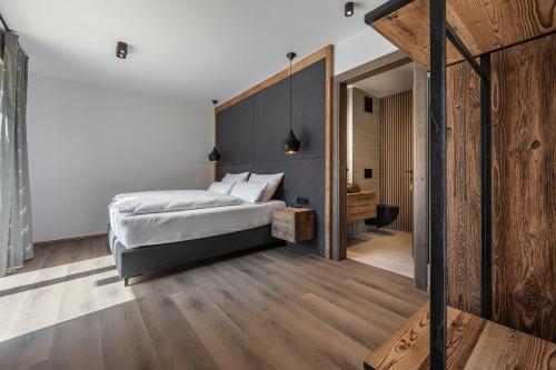 a bedroom with a bed with a wooden headboard at Kellnergut Luxus-Chalet "FRIEDA" in Mühlbach am Hochkönig